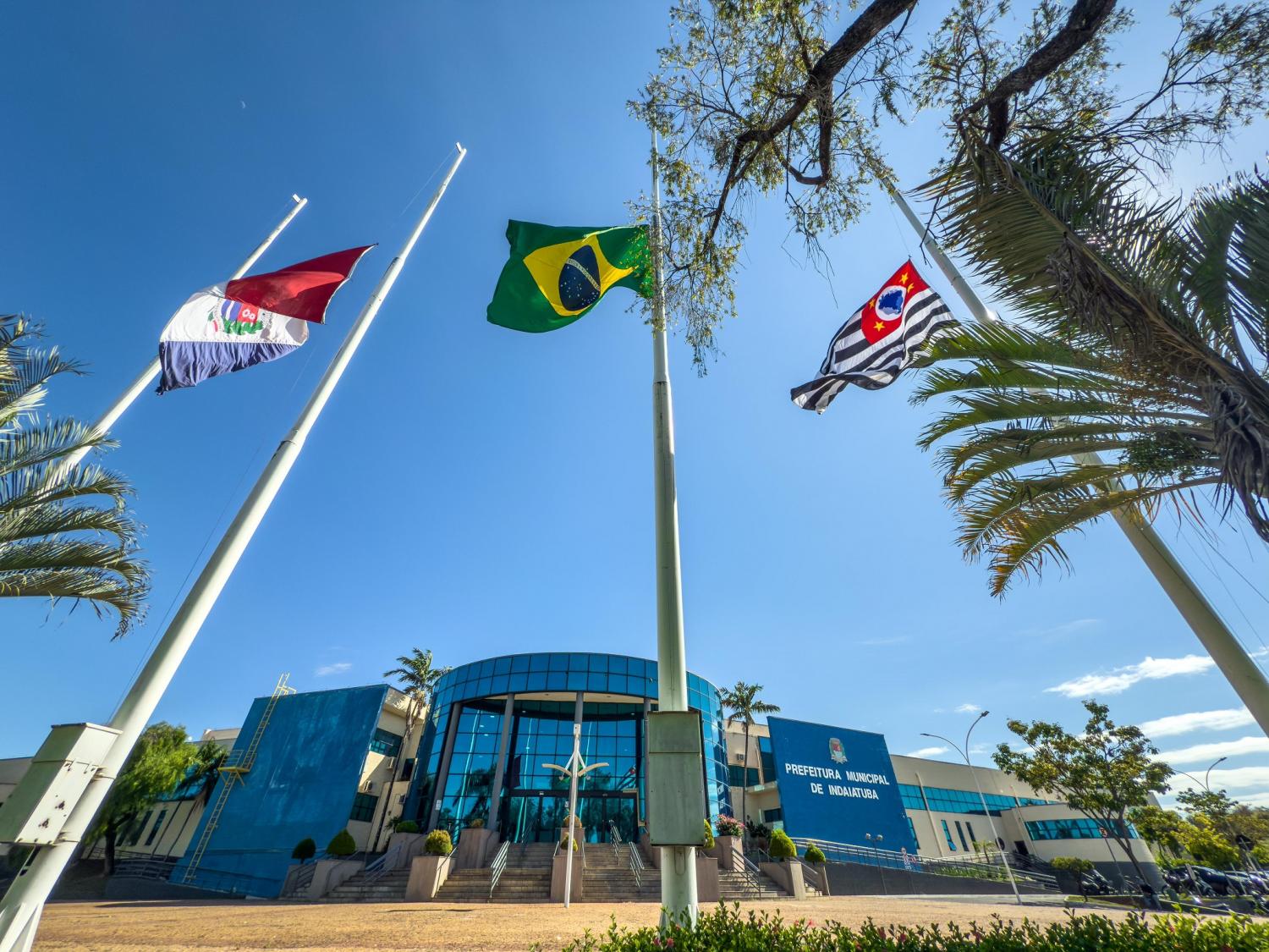Fachada de prédio de prefeitura municipal no Brasil, com bandeiras hasteadas. Imagem ilustrativa.