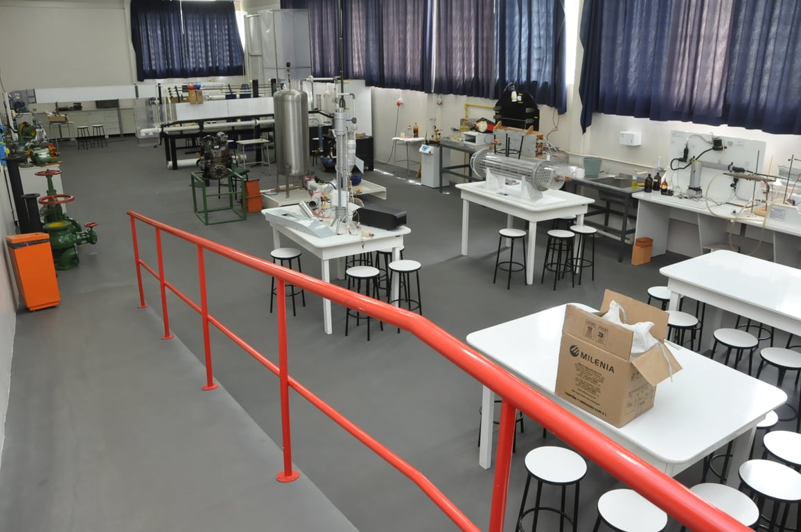 Laboratório de engenharia mecânica, com bancadas e equipamentos de pesquisa em ambiente universitário