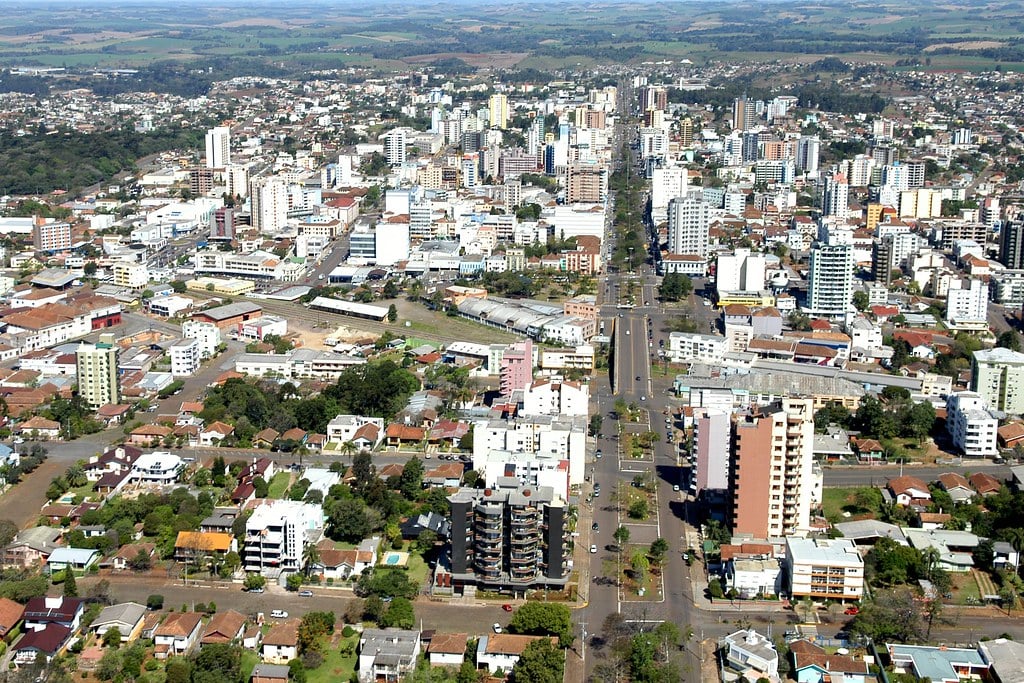 Vista aérea do centro de Erechim, com avenidas largas, praças e áreas verdes em dia claro