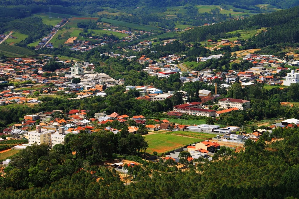 Vista aérea de Laurentino SC com morros ao fundo e céu claro