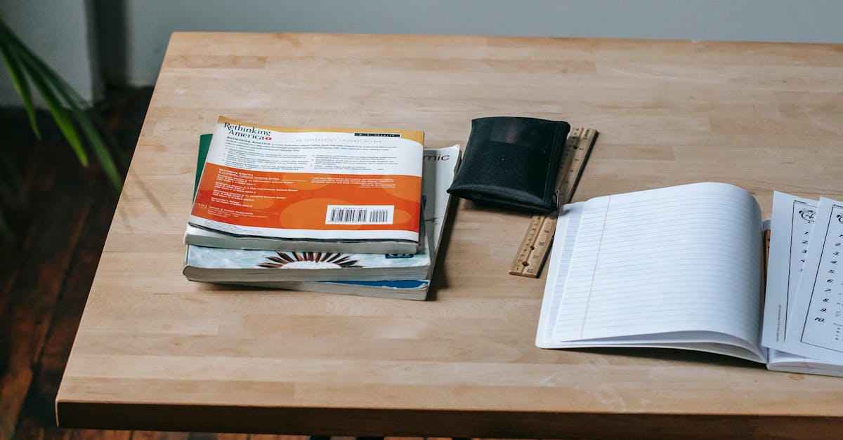 Mesa de estudos com caderno, livros e notebook, ilustrando preparação para concursos