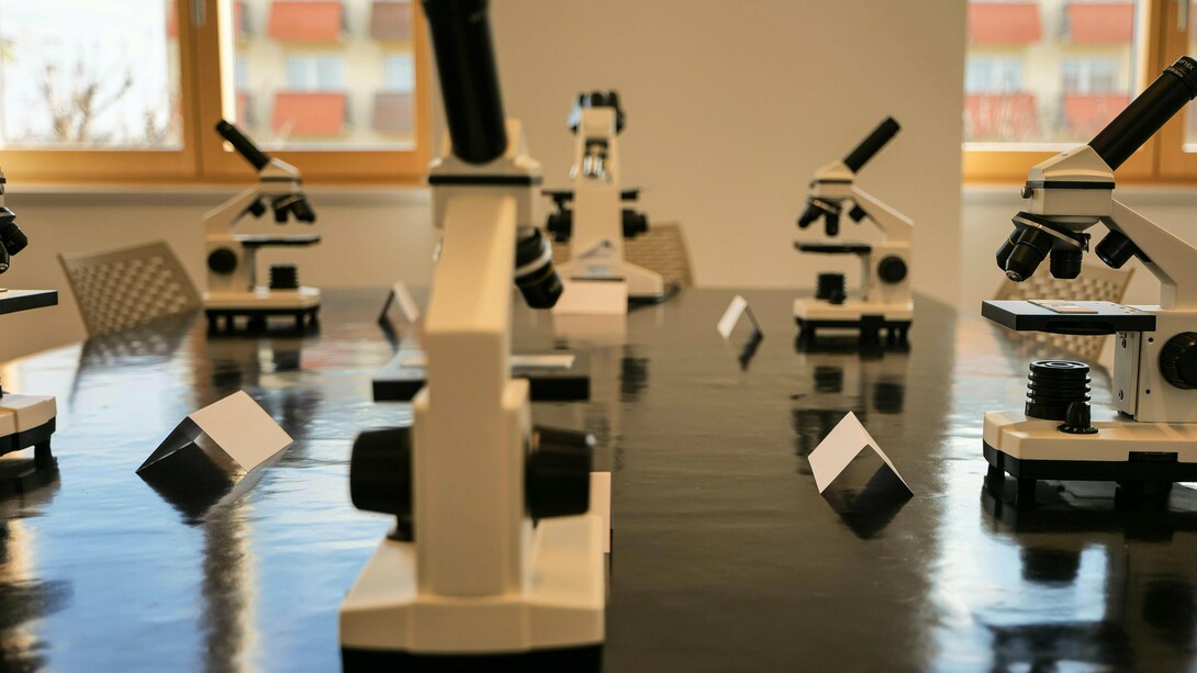 Ambiente de laboratório universitário com microscópios, simbolizando pesquisa e inovação