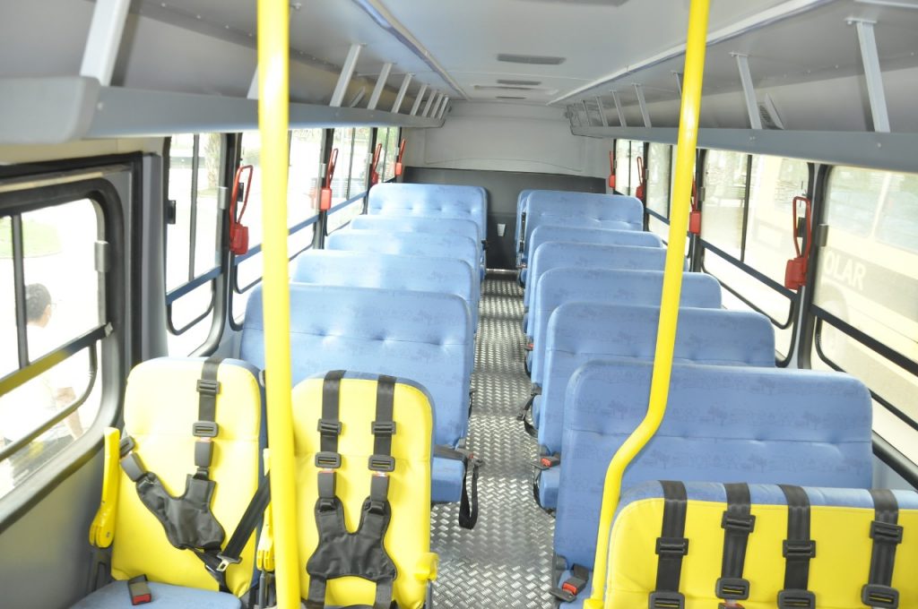 Interior de ônibus escolar, assentos amarelos e corredor central, imagem ilustrativa do cargo de motorista