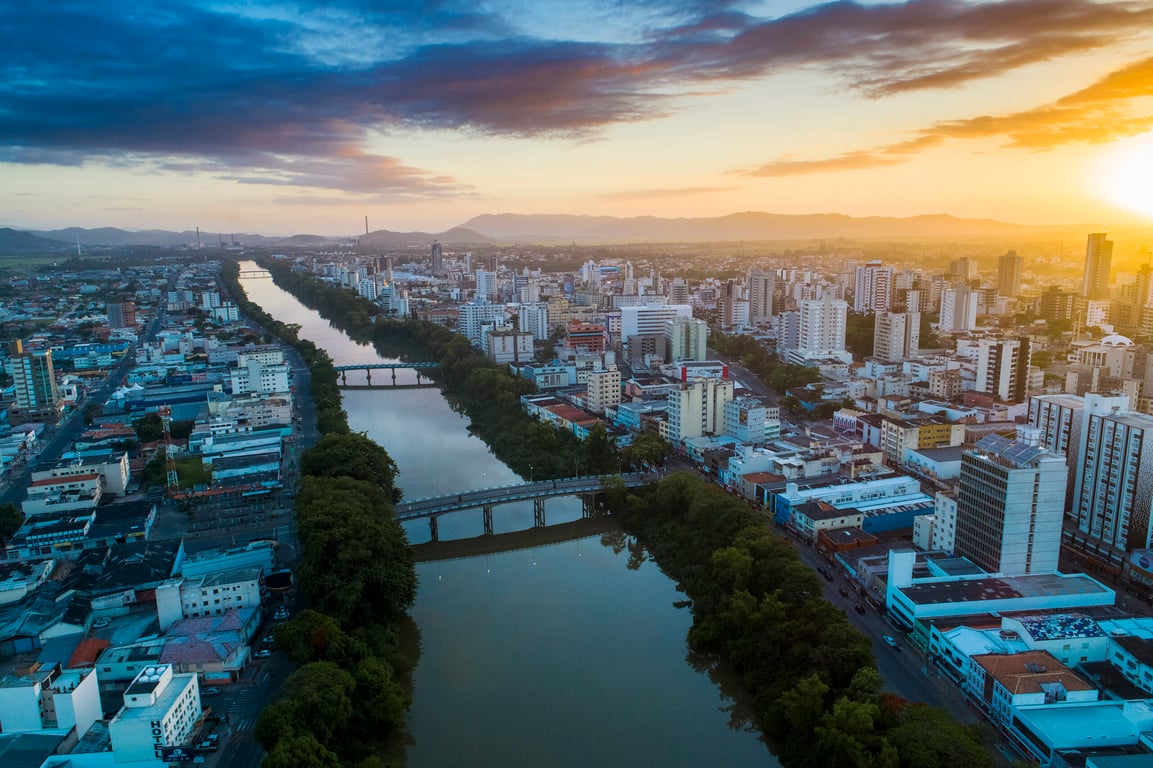Vista aérea da região de Tubarão/Capivari de Baixo, com rio e pontes sob céu azul