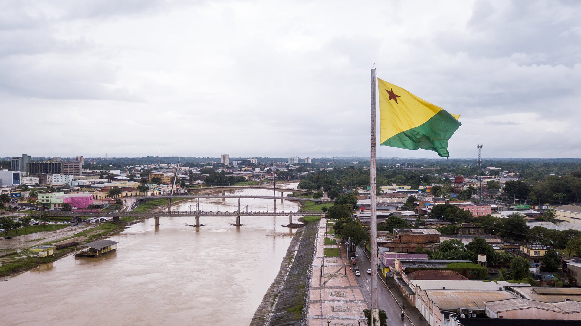 Vista aérea de Rio Branco ao entardecer, com ponte e rio em destaque