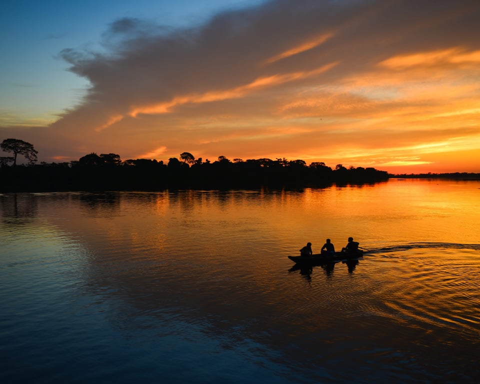Paisagem amazônica com rio e canoa ao entardecer, representando Silves AM