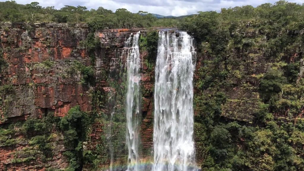 Vista da Serra Ricardo Franco com paredões verdes e céu parcialmente nublado