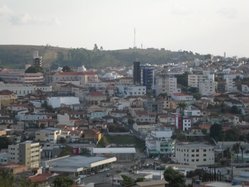 Vista de Oliveira Fortes MG, com relevo ondulado e área urbana entre morros verdes