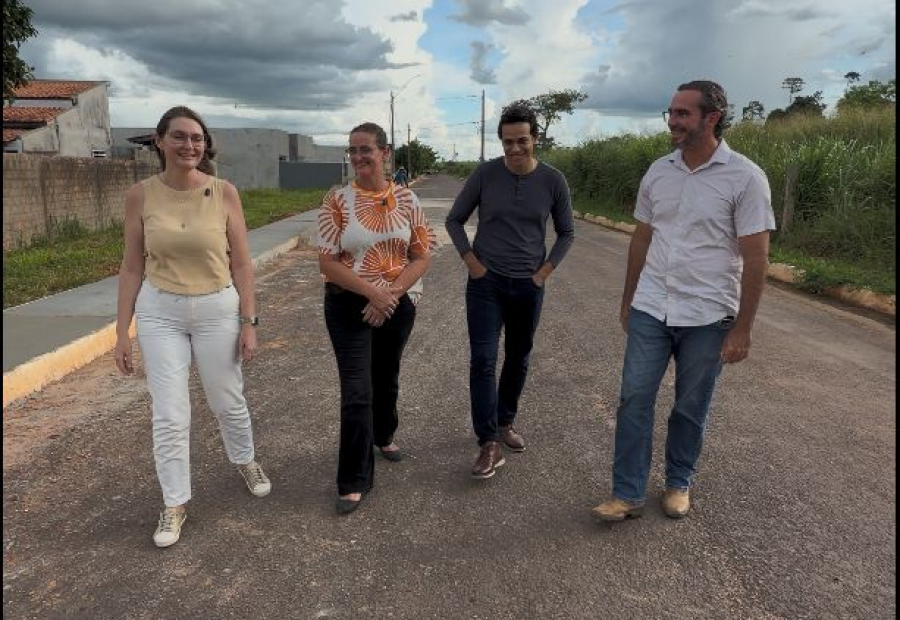 Cena urbana de cidade pequena no interior, com pedestres em rua arborizada