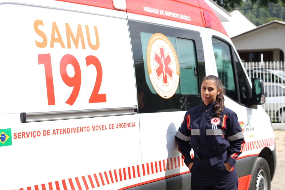 Ambulância do SAMU com profissional de saúde ao lado, em área urbana, destacando o serviço de emergência 192