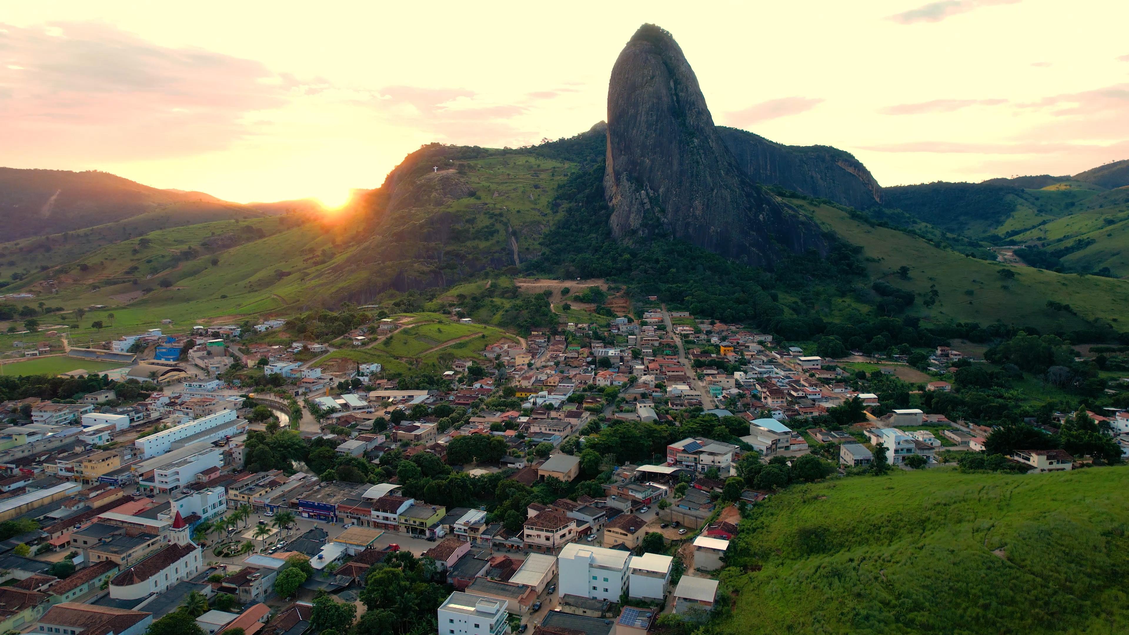 Vista aérea de cidade do interior de Minas Gerais, com morros ao fundo e traçado urbano em vale