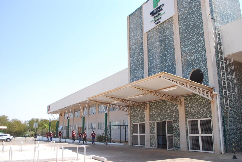 Prédio do Instituto Federal, com estudantes caminhando em direção à entrada, em dia ensolarado
