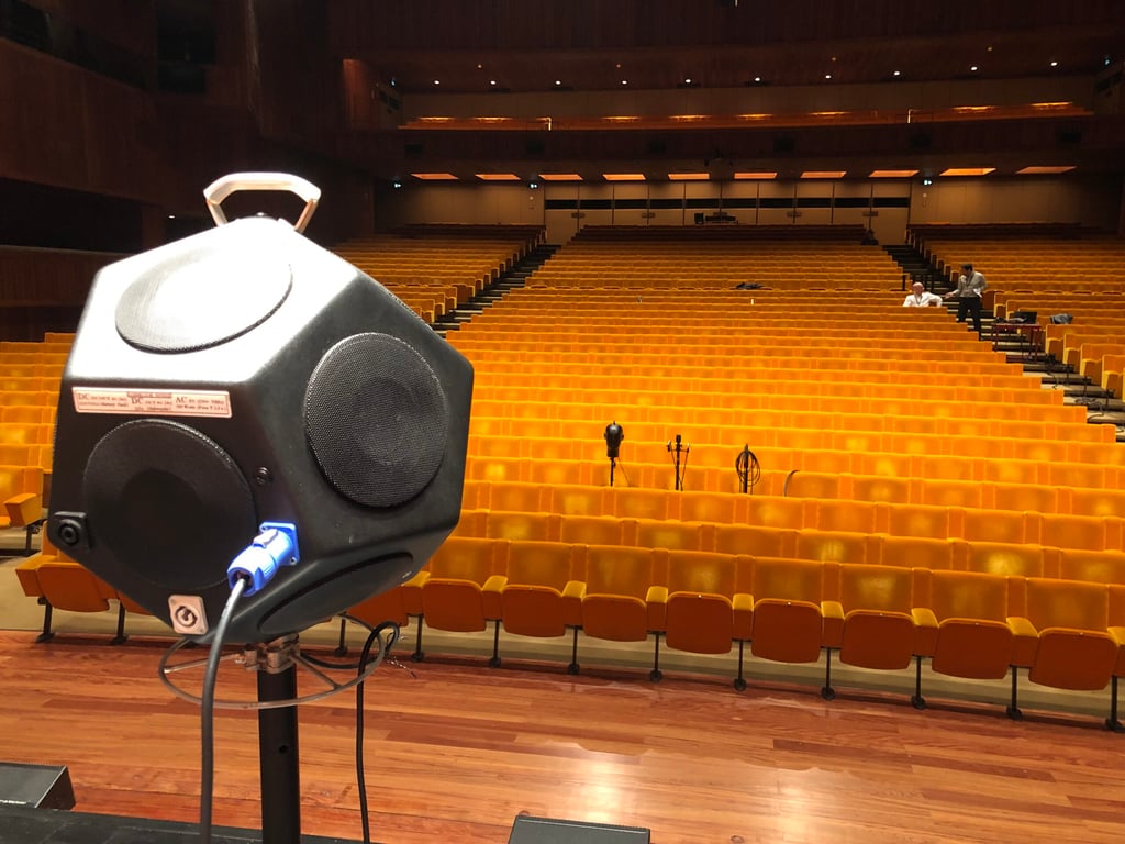 Plenário moderno de câmara municipal, com mesas e microfones