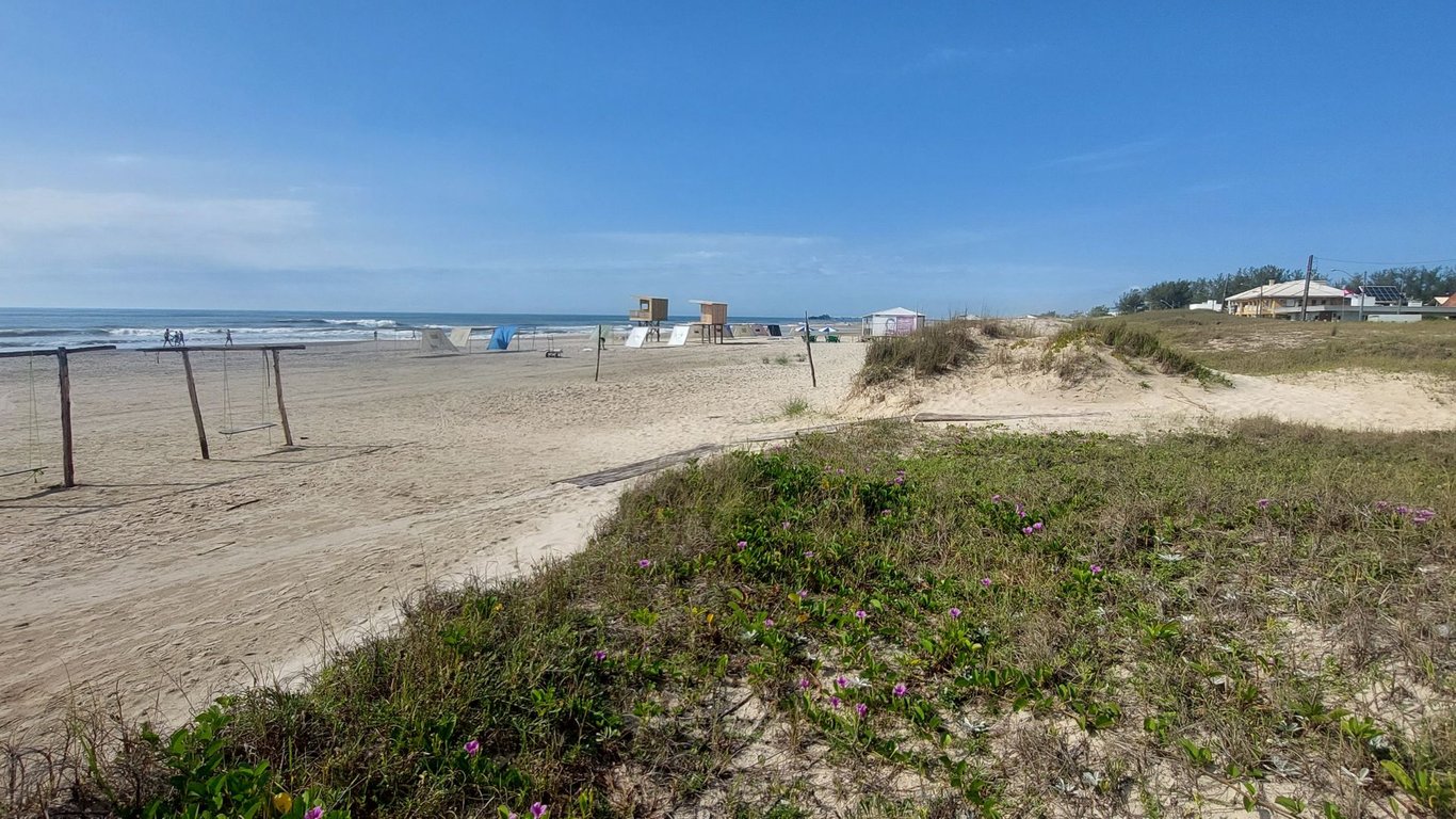 Orla de Imbé RS com praia, vegetação e área urbana ao fundo