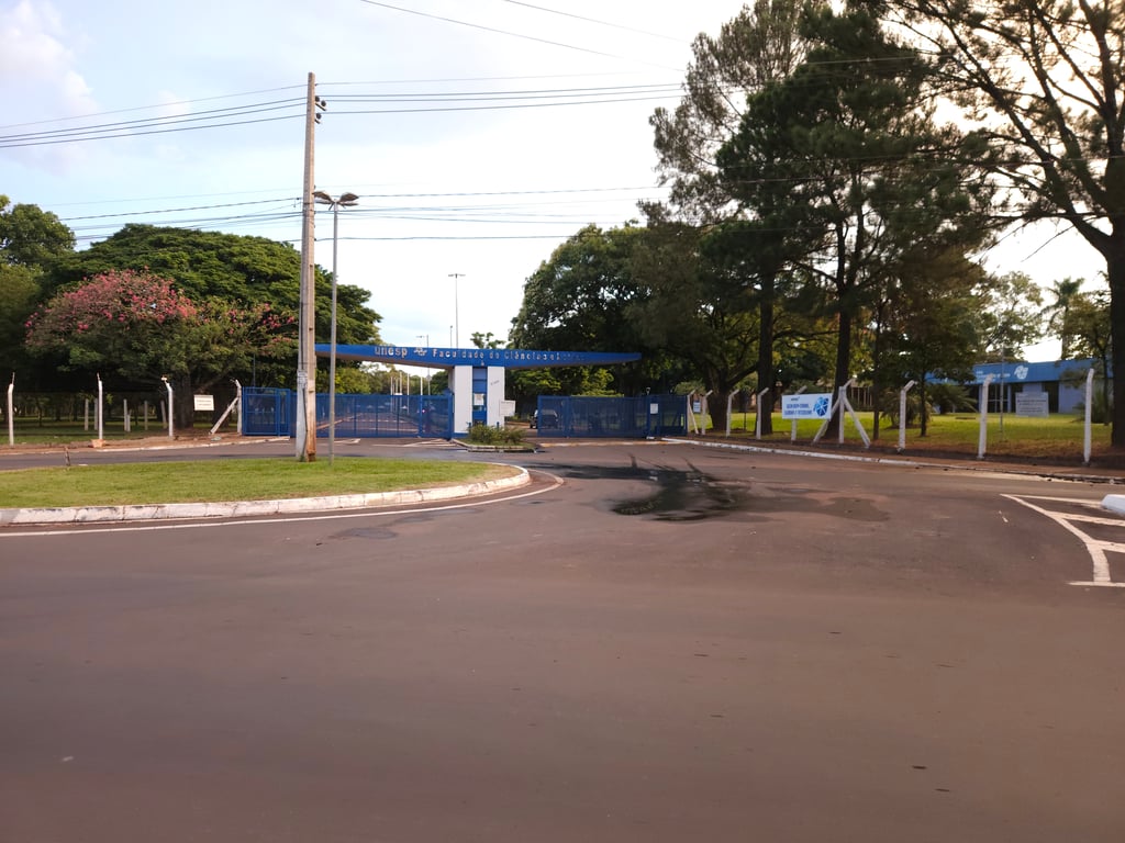 Entrada da Faculdade de Ciências e Letras da UNESP em Assis, com áreas verdes e prédio ao fundo