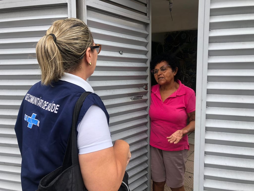 Agente comunitário de saúde em visita domiciliar, em área urbana.