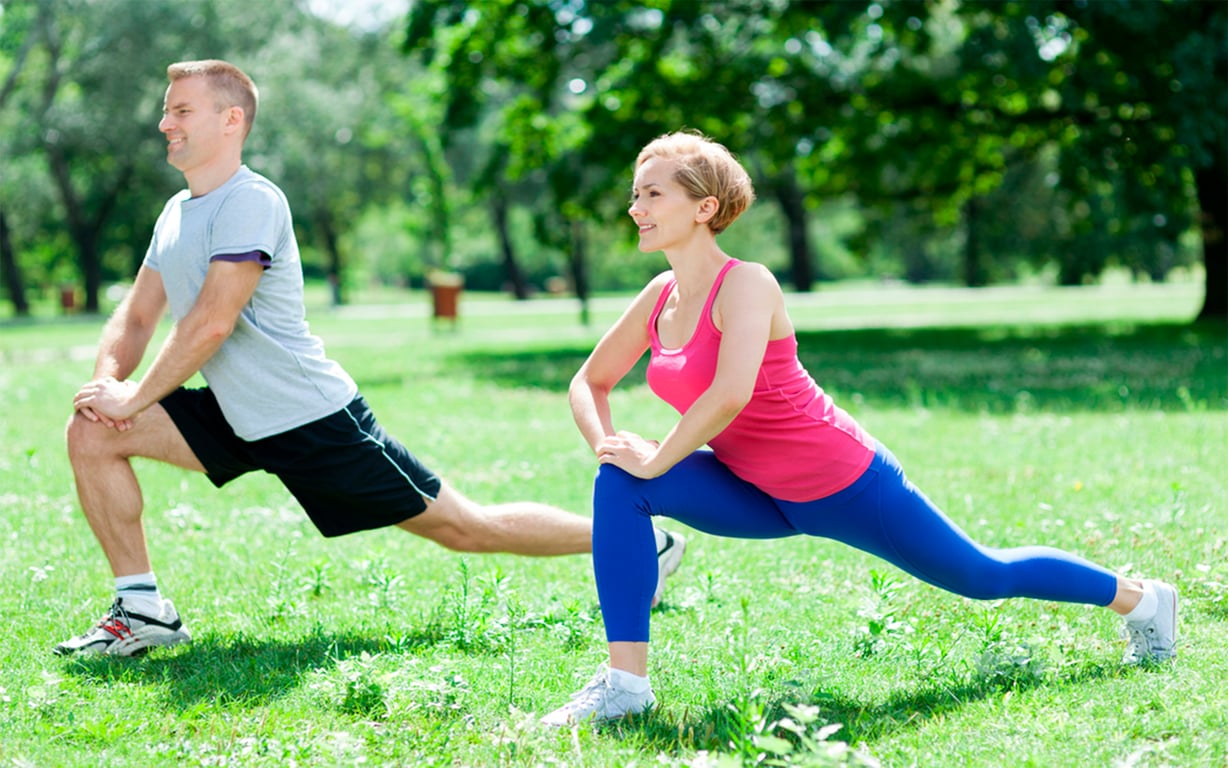 Grupo praticando exercícios em parque, com instrutor