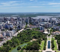 Vista panorâmica de Porto Alegre ao entardecer, com a skyline do centro histórico e o Guaíba ao fundo.