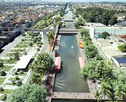 Paisagem ribeirinha no Pará, com canal, vegetação e área urbana ao fundo