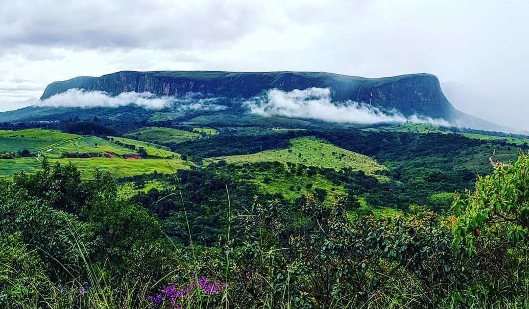 Paisagem montanhosa da região da Serra da Canastra, com céu parcialmente nublado e vegetação típica do Cerrado mineiro