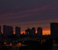 Skyline de Campinas ao entardecer, destaque para polo tecnológico e acadêmico.