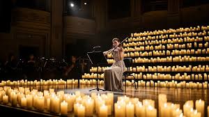Flautista em apresentação de música de câmara; foco nas mãos e na flauta transversal, iluminação quente de palco