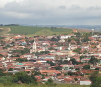 Paisagem urbana de São Miguel Arcanjo SP com morros verdes ao fundo.