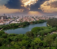 Vista aérea de uma cidade com prédios e áreas verdes ao entardecer