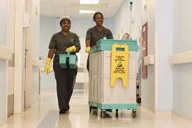 Equipe de limpeza hospitalar realizando higienização em corredor de hospital