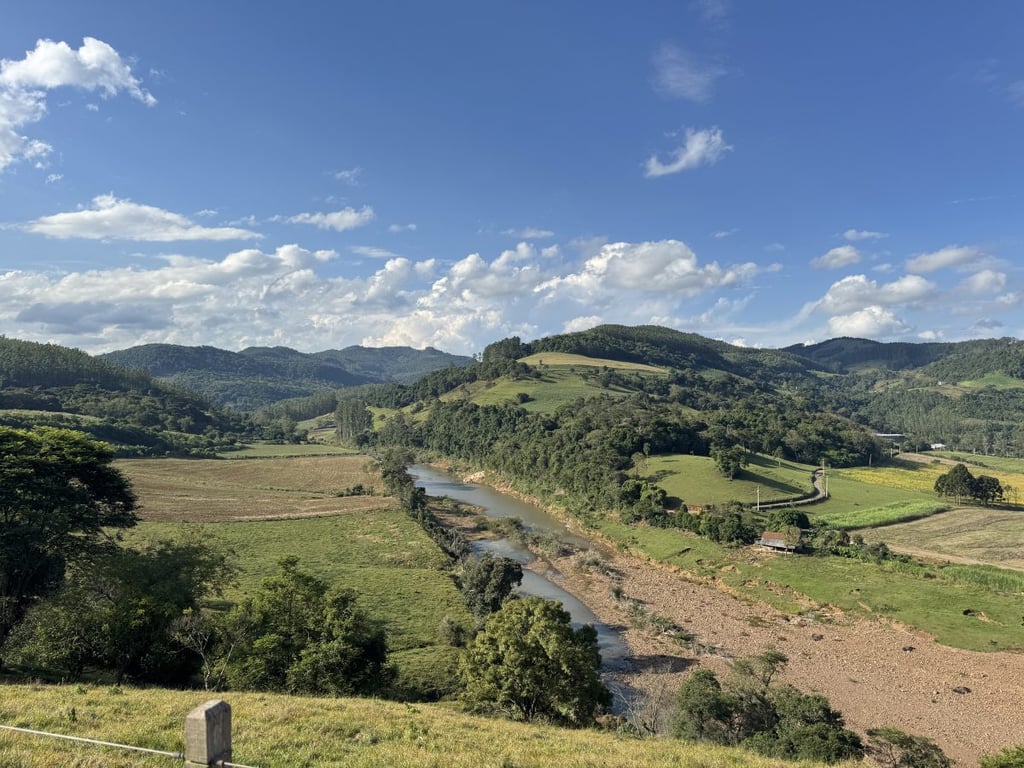 Paisagem rural no Vale do Taquari RS, com morros ao fundo e um rio ao centro, ao amanhecer