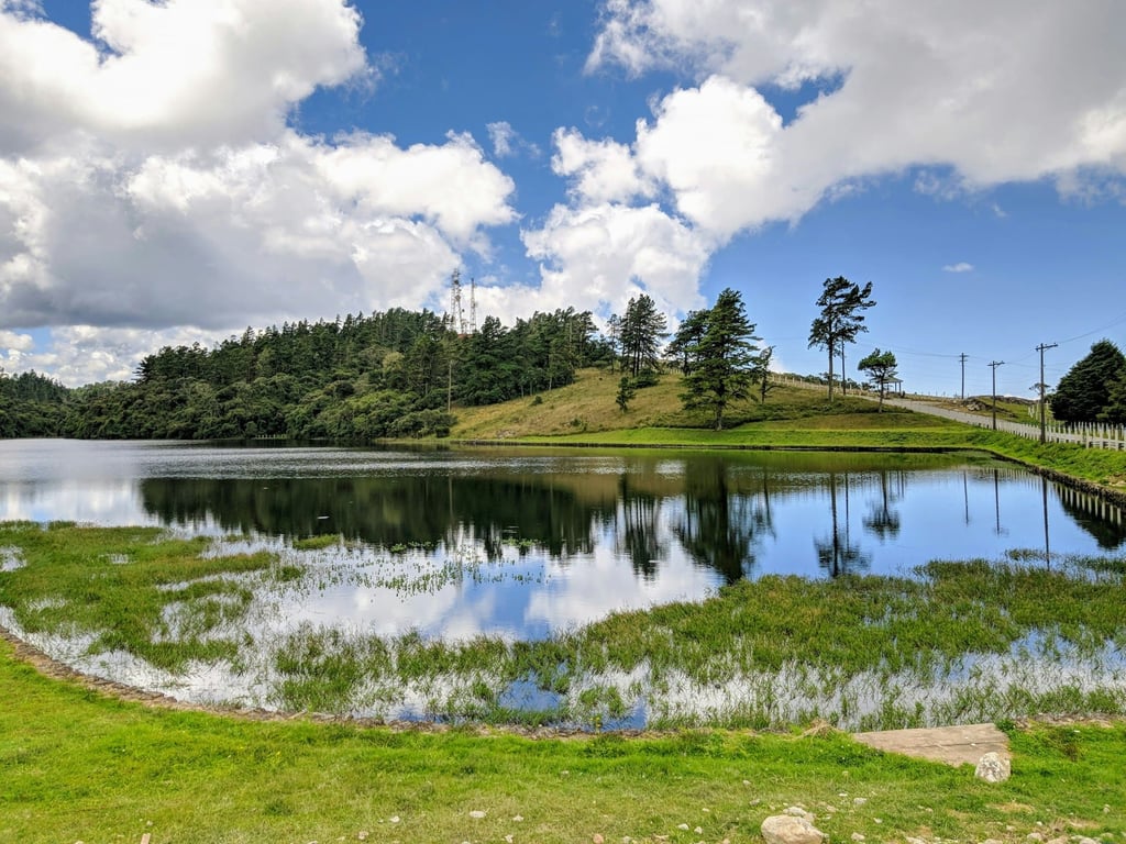 Serra da Mantiqueira ao entardecer, com montanhas e lago em primeiro plano