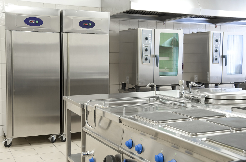 Cozinha industrial hospitalar com equipamentos inox e bancada de trabalho