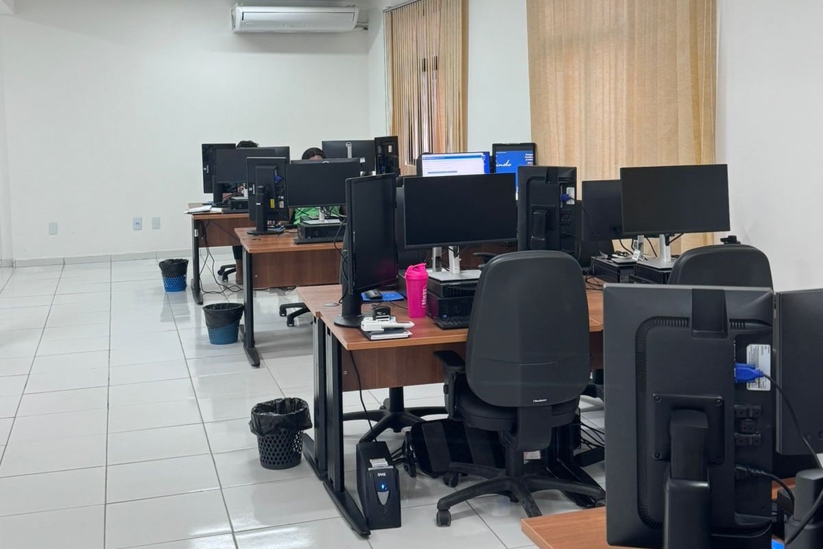 Ambiente de escritório público com mesas e computadores, ilustrando rotinas administrativas