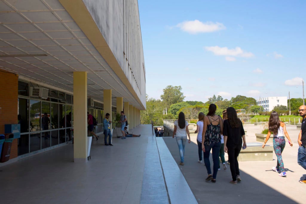 Campus da UFSM com áreas verdes e circulação de estudantes