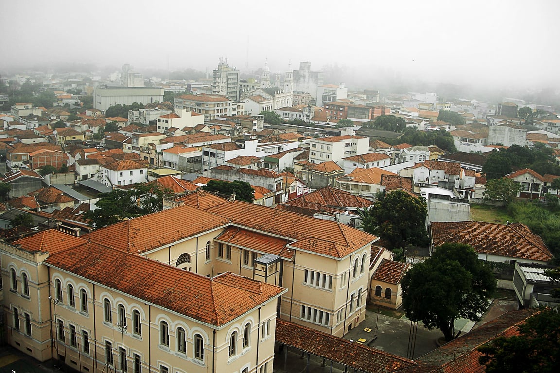 Vista aérea de cidade do Vale do Paraíba, com construções históricas e serra ao fundo