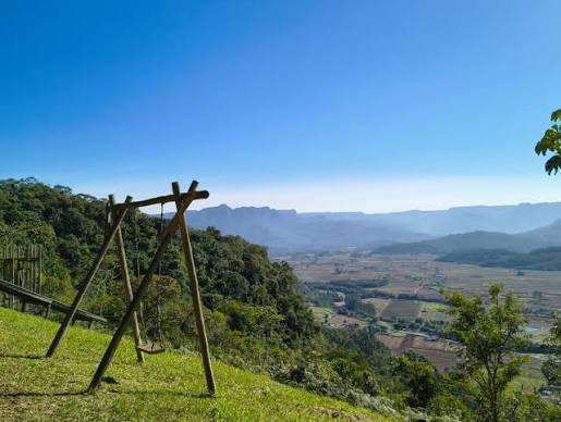 Estrada cercada por morros e vegetação nativa na região de Maquiné RS