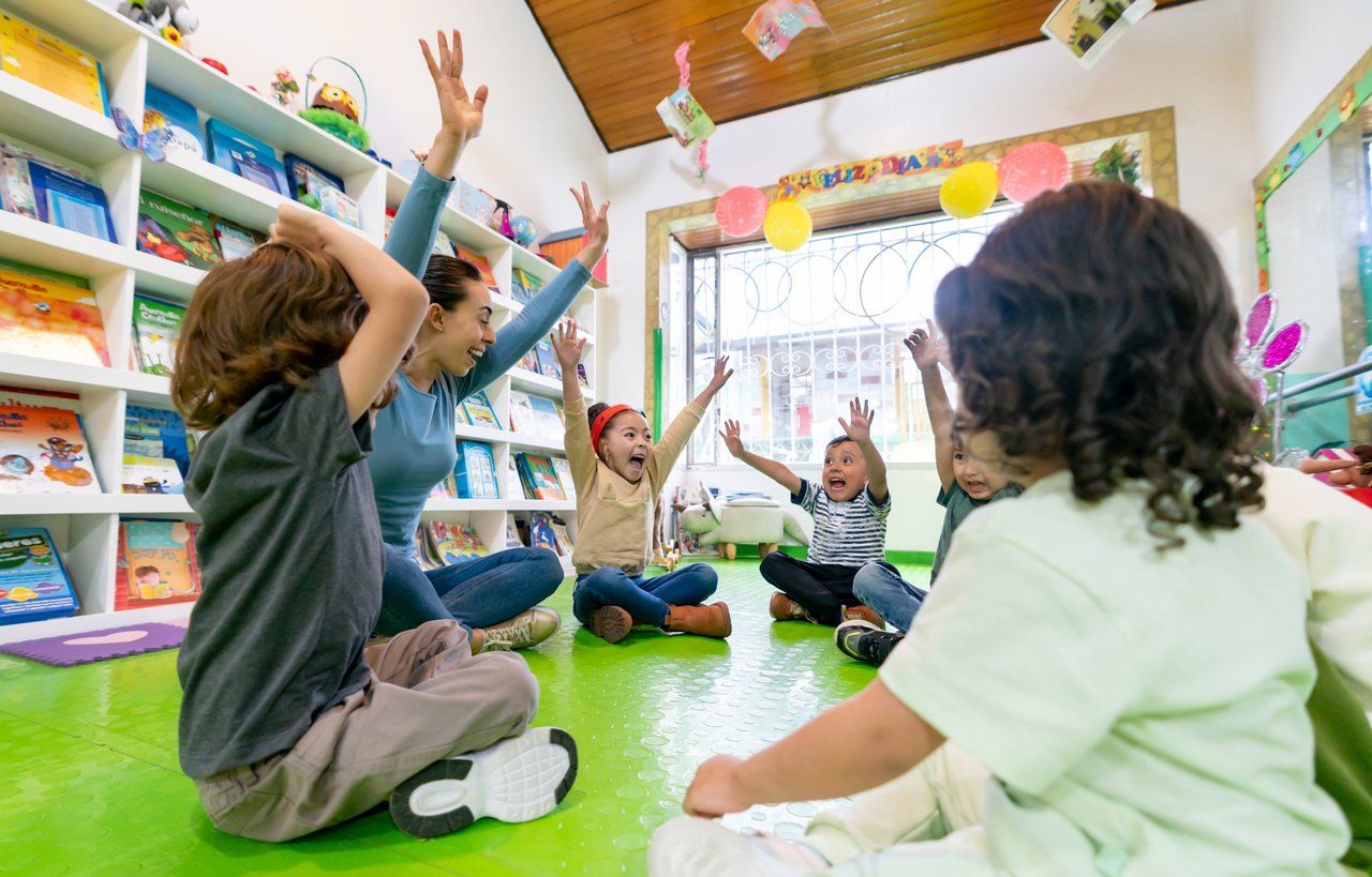 Professora interage com crianças em sala de aula da Educação Infantil