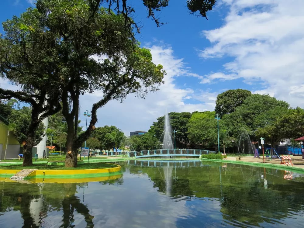 Paisagem urbana arborizada de Tupã (SP) ao entardecer, com lago e fontes