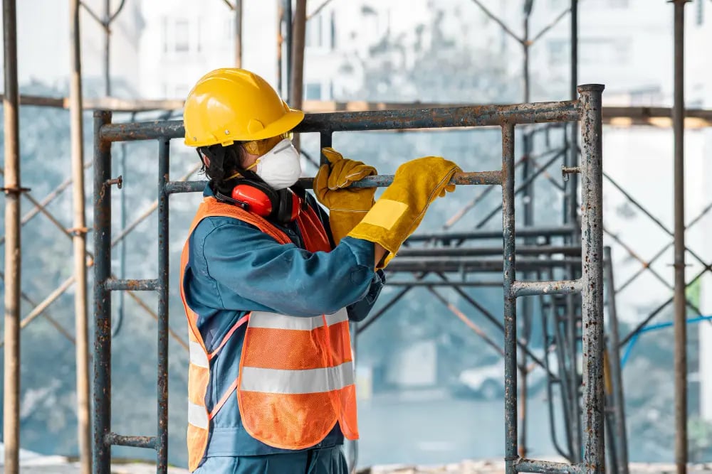 Trabalhador de obras públicas com EPI, em ambiente externo, foto horizontal.