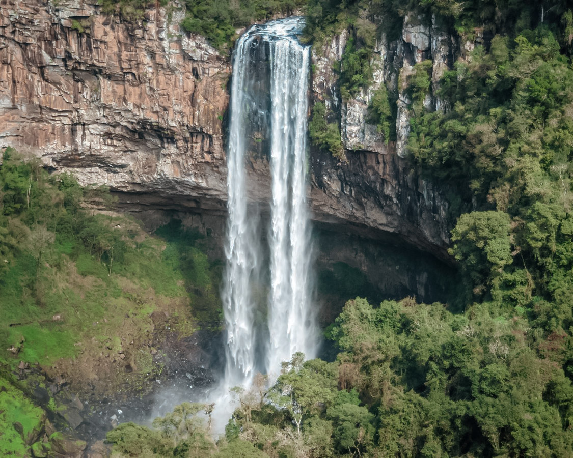 Paisagem da Serra Gaúcha com vegetação e cachoeira, remetendo ao ambiente natural de Nova Pádua RS