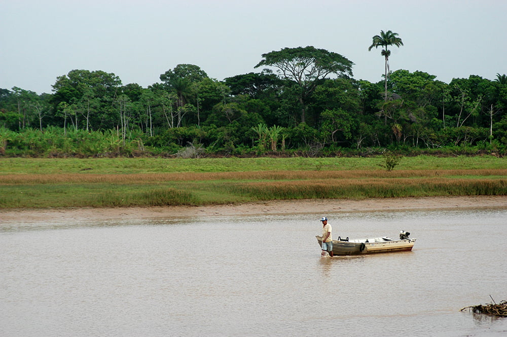 Rio Itapecuru em Itapecuru-Mirim, vegetação densa e pequena embarcação no espelho d’água