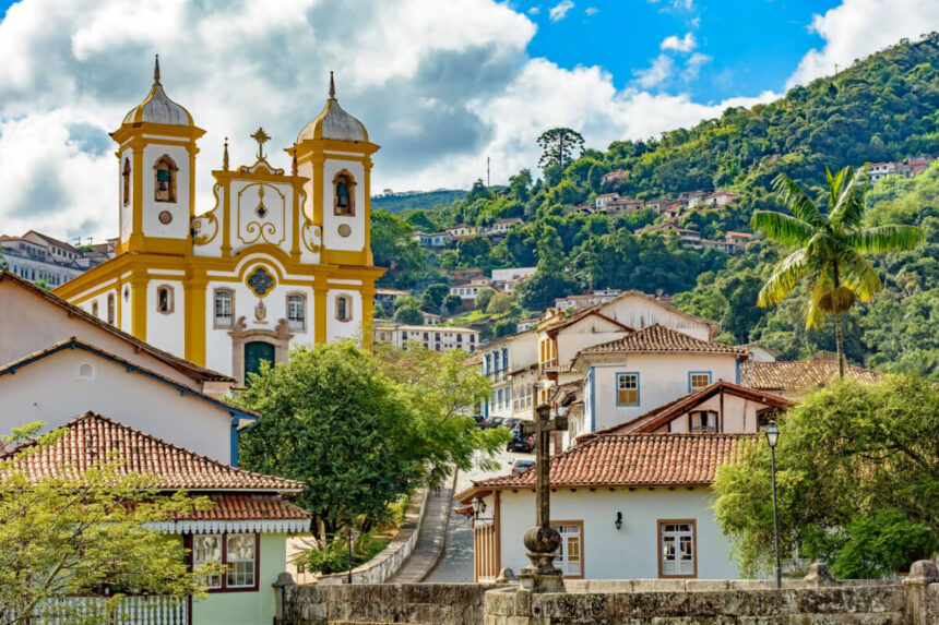Vista de Ouro Preto ao pôr do sol, com igrejas históricas e montanhas ao fundo