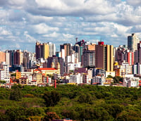 Vista aérea de Divinópolis MG, com skyline baixo e vegetação sob céu claro