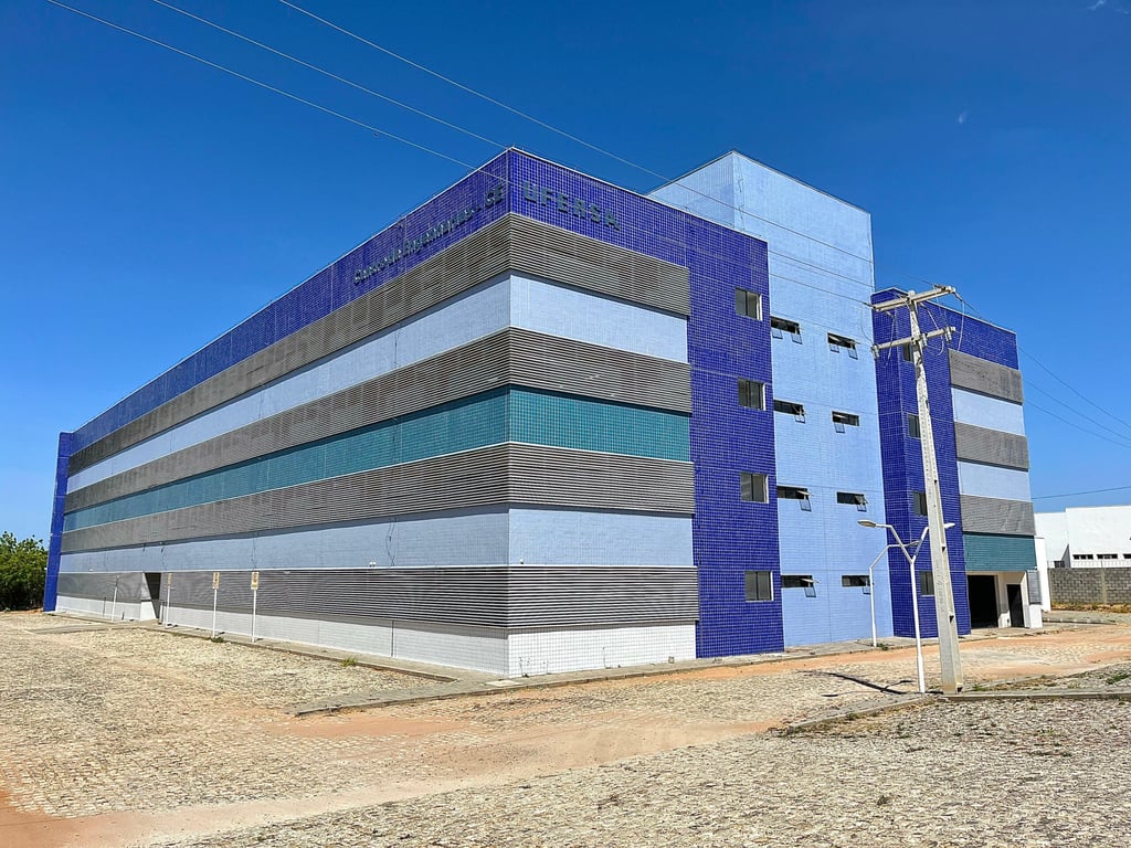 Fachada do campus da UFERSA em Mossoró, com prédios modernos e céu azul