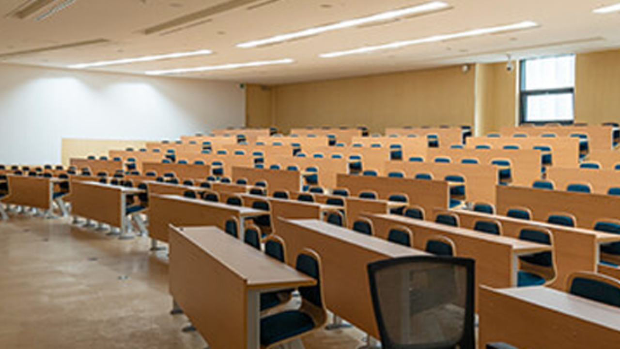 Sala de aula moderna, bem iluminada, com mesas e cadeiras organizadas
