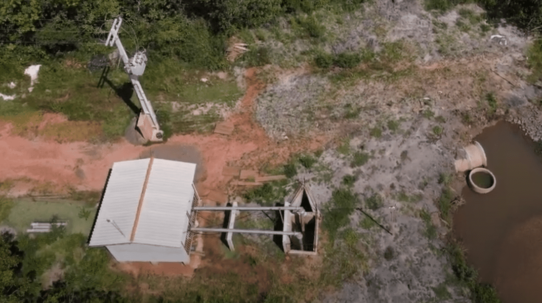 Vista aérea do interior do Centro-Oeste, com áreas rurais, galpões e vegetação ao entardecer
