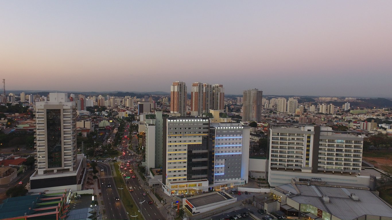 Paisagem urbana de Jundiaí, com áreas verdes e prédios ao fundo, no fim da tarde