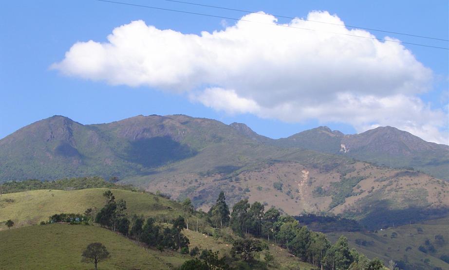 Vista de cidade no Sul de Minas, com morros ao fundo, remetendo à Serra da Mantiqueira
