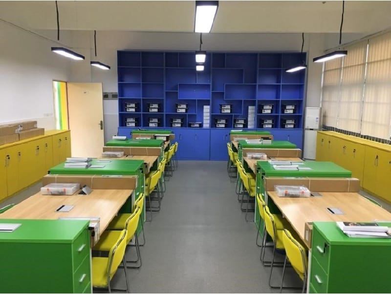 Sala de aula moderna e iluminada com mesas e cadeiras coloridas