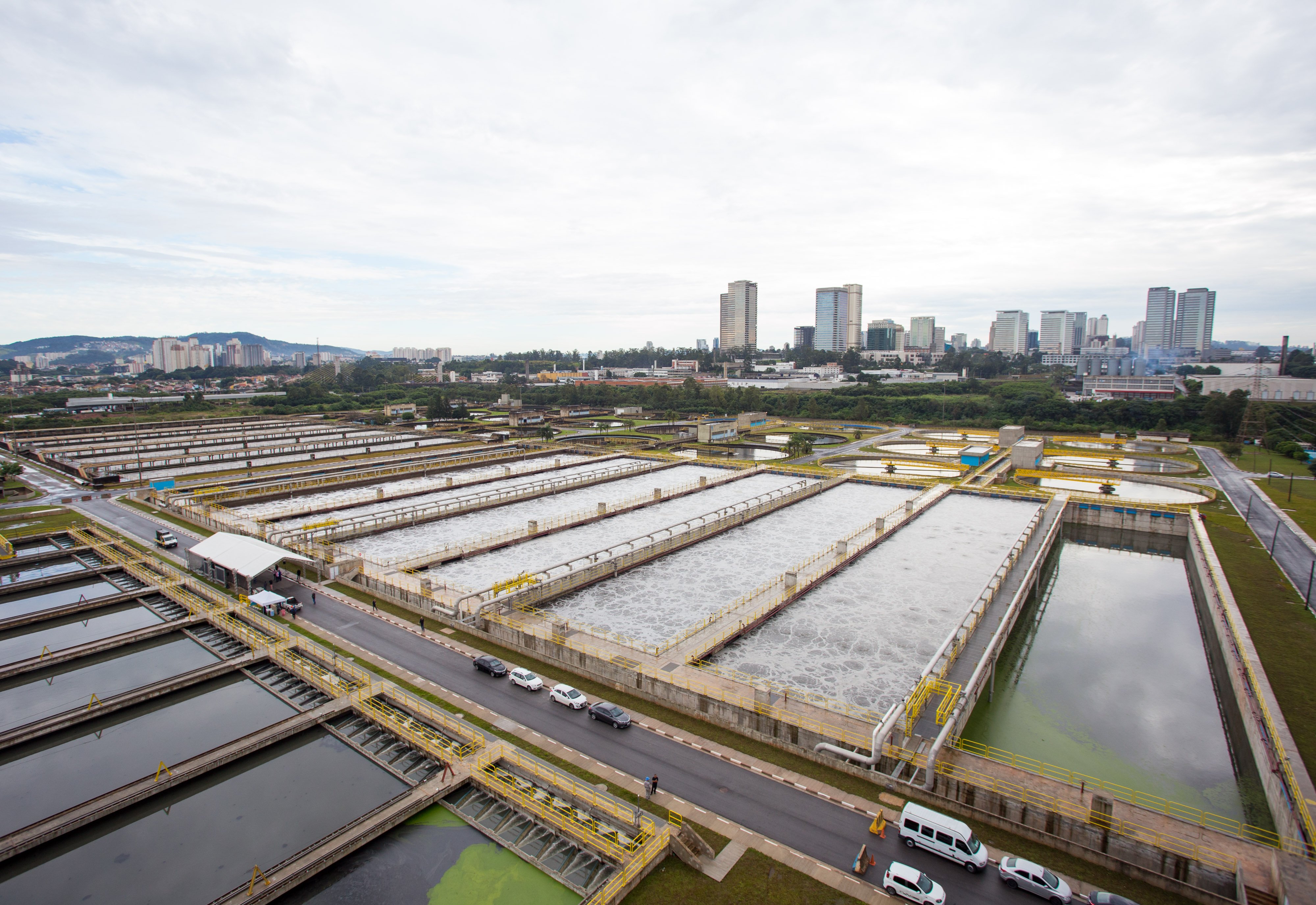 Estação de tratamento de água com tanques e tubulações em área urbana